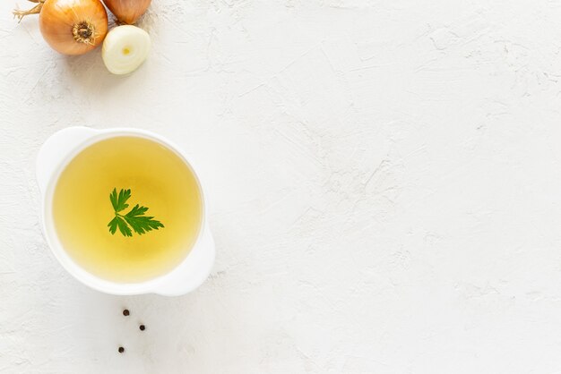 Kippenbottenbouillon met peterselie in een witte kom