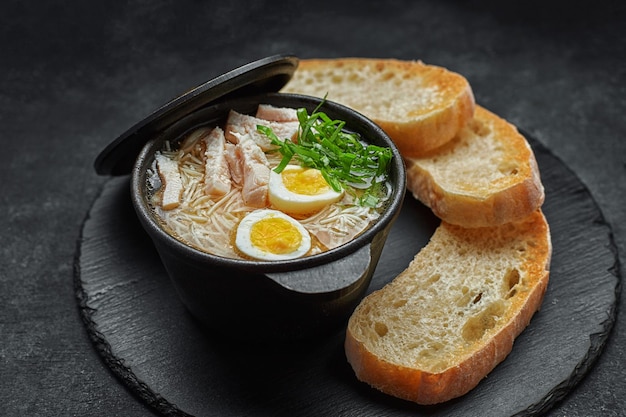 Kippenbouillon met ei en croutons in een pan