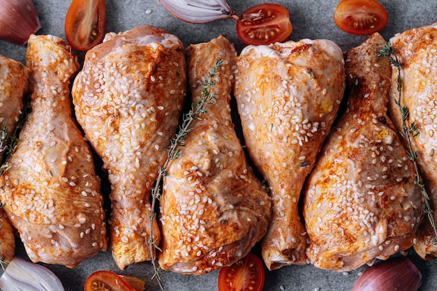 Kippenboutjes met kruidenpaprika en sesamzaadjes klaar om te bakken op een bakplaat