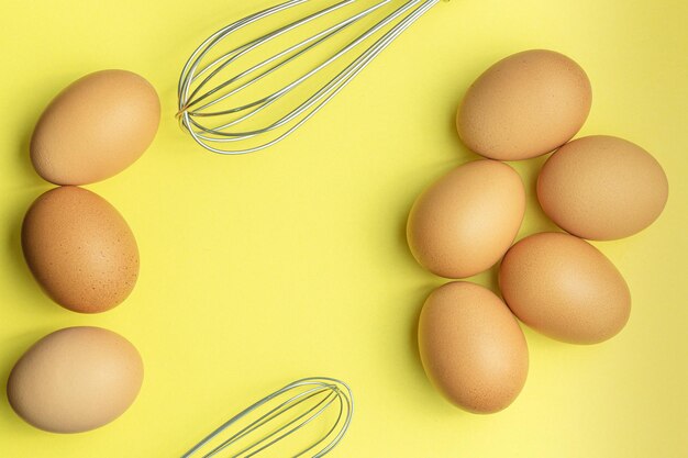 Kippeneieren bruine eieren gebroken ei in kartonnen doos op gele achtergrond Bovenaanzicht natuurlijke eieren in ca