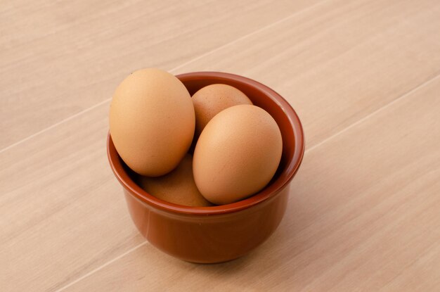 Kippeneieren in een bruine kom Eieren zijn een rijke bron van selenium, een antioxidant die belangrijk is voor de schildklier.