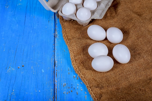 Kippeneieren in een kartondoos op een houten lijst. Eigeel koken