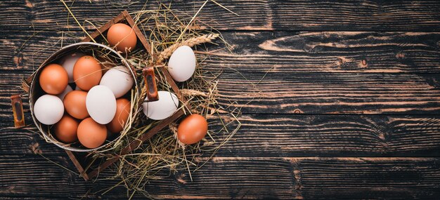 Kippeneieren in een metalen pan Op een houten ondergrond Bovenaanzicht Kopieer de ruimte