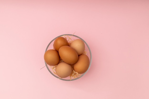 Kippeneieren in een transparante plaat op een roze achtergrond