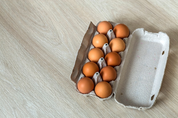 Kippeneieren in open kartonnen eierdoos op keukentafel. Gezonde biologische voeding en dieet concept.