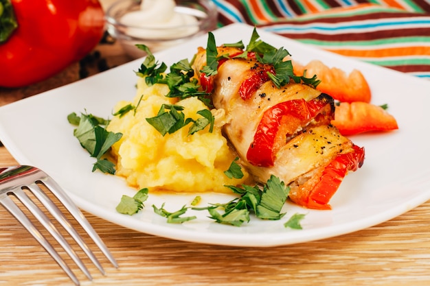 Kippenfilet gebakken met peper en aardappelpuree op een bord