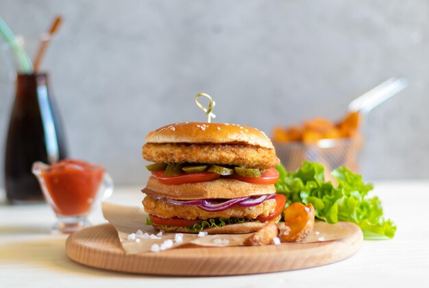 Foto kippenhamburger met de ketchupfles van ketchup van aardappelpartjes op lichte achtergrond