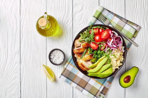 kippenkom met couscous, groenten, avocado, lente-ui en rucola