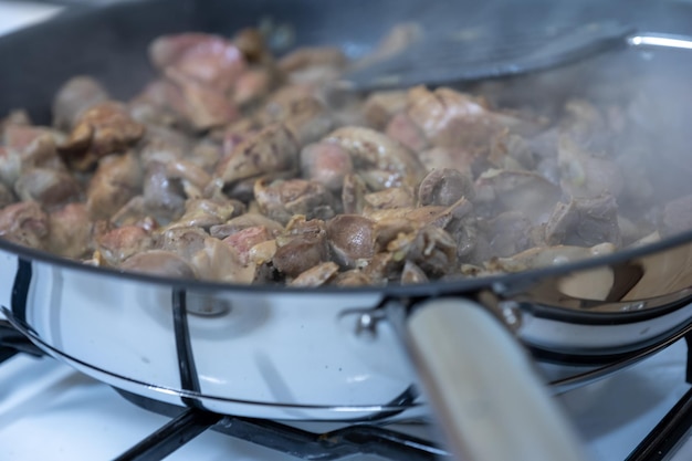 Kippenmaaglevers en harten koken met pan