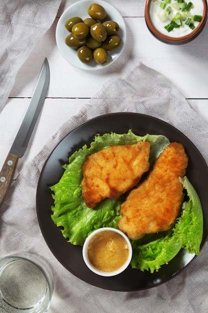 Kippenschnitzel en sla met olijven