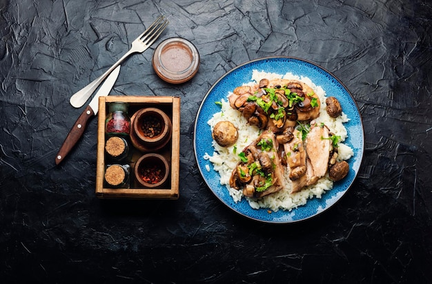 Kippenvlees met champignonsaus op een rijstpad. Vlees met Siciliaanse marsalasaus.