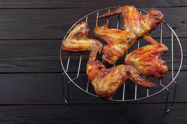 Kippenvleugels en -poten koken op een grill.