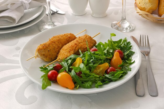 Kipschnitzel garnituur van rucola en tomaten