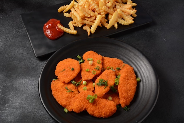 Kipschnitzel of nuggets met friet en ketchup