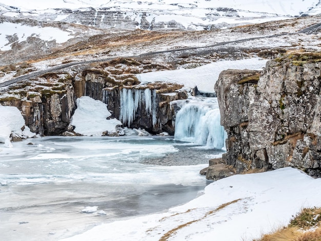 Kirkjufellfoss waterfall with its surrounding view water freeze the most popular landmark in Iceland