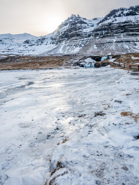 Kirkjufellfoss-waterval met zijn omringende uitzicht water bevriest de meest populaire bezienswaardigheid in IJsland