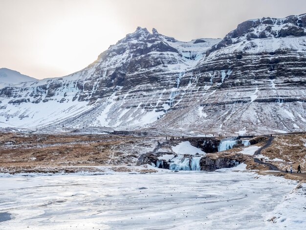 Kirkjufellfoss-waterval met zijn omringende uitzicht water bevriest de meest populaire bezienswaardigheid in IJsland