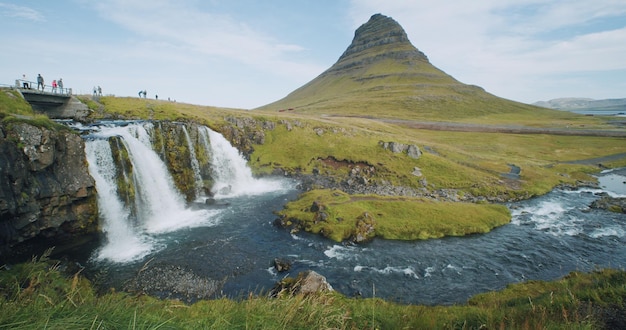 북부 아이슬란드의 Kirkjufellsfoss 및 Kirkjufell 다리에 인식할 수 없는 toursit 사람들