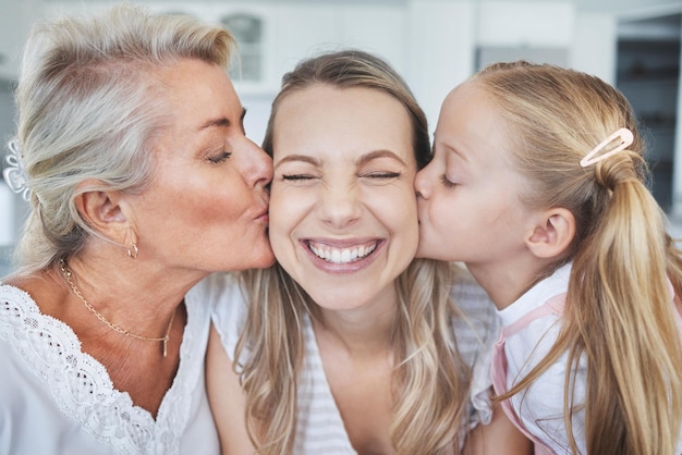 Целуйте ребенка и бабушку с любовью к матери в день матери в гостиной своего дома Девушка и пожилая женщина целуют маму с нежностью, заботой и улыбкой, чтобы выразить благодарность в своем доме