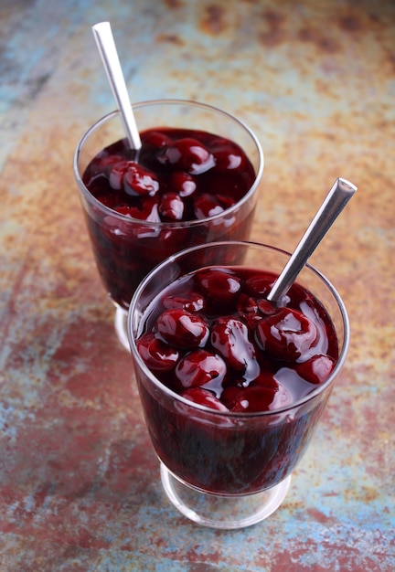 Kissel with cherries in a glass on an old background