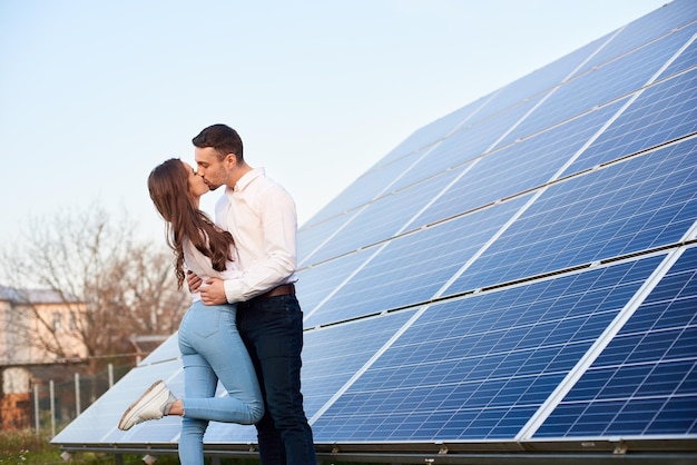 Foto baciare le coppie vicino al pannello solare