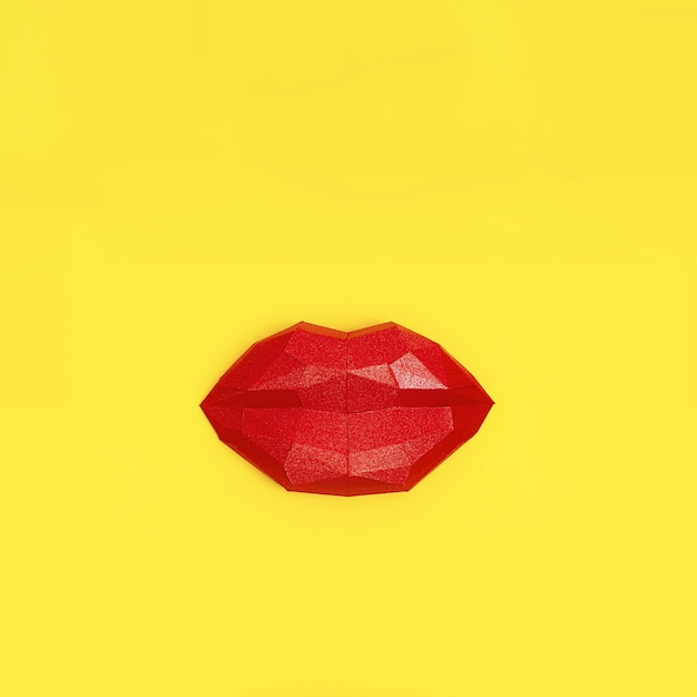 Kissing woman lips red colored on yellow paper background.