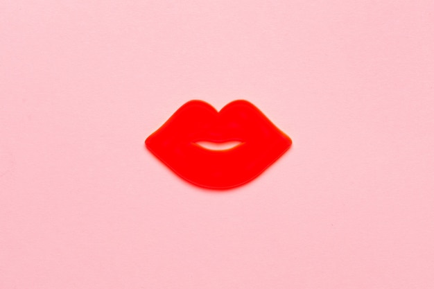 写真 キスをする女性の唇は紙にピンク色に輝いています。