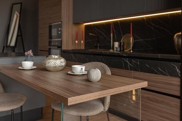 Kitchen area in a chic expensive interior of a luxury home with a dark black and brown modern design with wood trim and led light