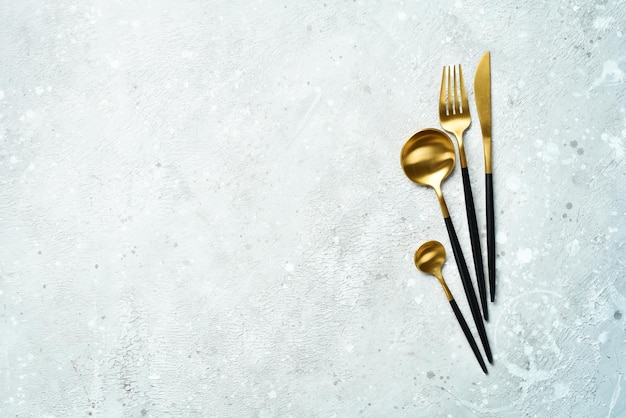 Kitchen background Metal cutlery On a gray stone background Top view