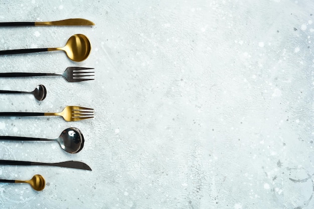 Kitchen background Metal cutlery On a gray stone background Top view