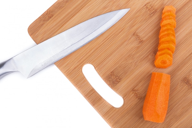 Kitchen board and knife for cutting carrots. Close-up.