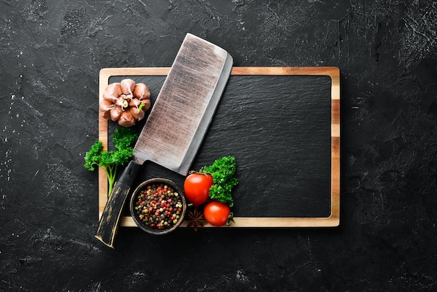 Kitchen board and spices Banner On a black stone background Top view Free space for your text