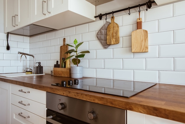 Foto utensili da cucina in ottone accessori da chef appesi da cucina con muro di piastrelle bianche