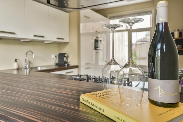 A kitchen counter with a bottle of wine and glasses