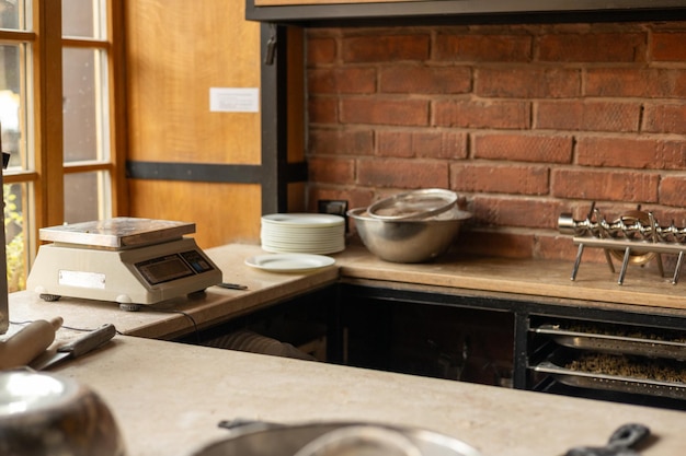 kitchen countertop with metal cookware and tools arranged neatly against a brick wall
