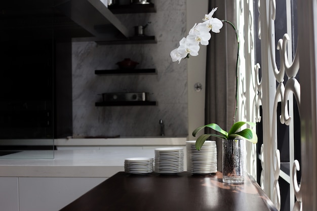 Kitchen decoration shelf with orchid flower near windows