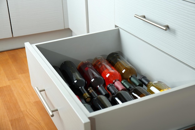 Kitchen drawer with assortment of wine bottles closeup
