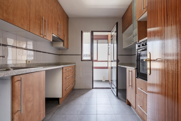 Kitchen furnished with woodcolored furniture and granite countertops