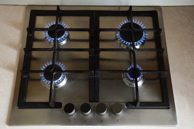 Kitchen gas stove with four red-hot burners burning blue flame