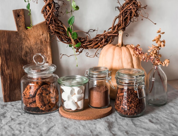 Kitchen interior cans of cookies granola cocoa marshmallows on the table Cozy home concept