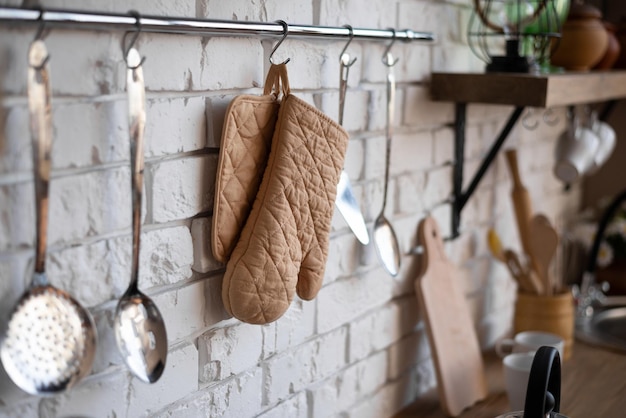 The kitchen interior. Ladles and a hot pot holder are hanging on the wall.