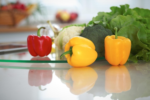 Interni della cucina molte verdure e altri pasti al tavolo di vetro sono pronti per essere cucinati presto