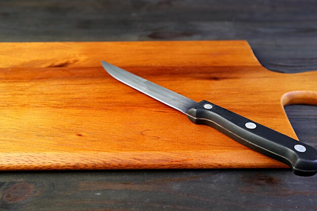 A kitchen knife on wooden cutting board for the concept of cooking