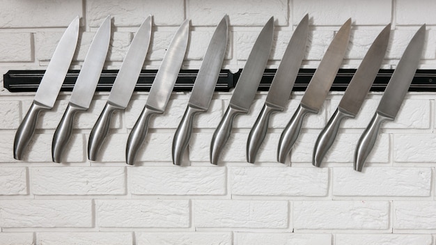 Kitchen knives set on white wall