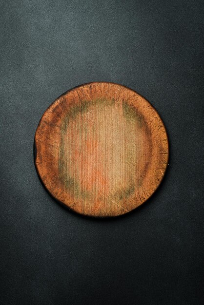 Foto tavolo da taglio rotondo di cucina tavolo marrone utensili da cucina su uno sfondo scuro