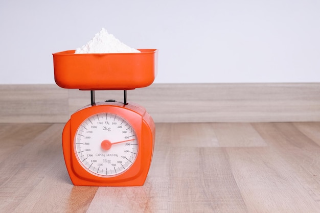 Kitchen Scales with Flour on Wooden Table