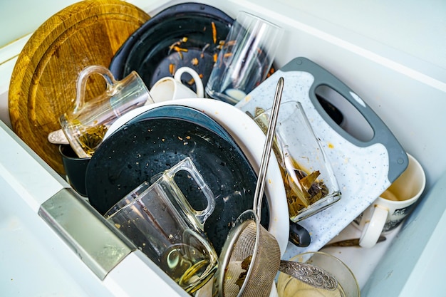 Kitchen sink with dirty dishes and utensils mess and sink dirty\
kitchen utensils