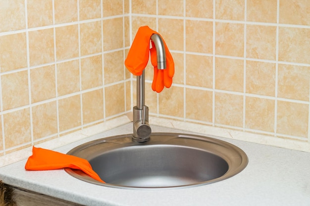 Kitchen sink with faucet and gloves for cleaning