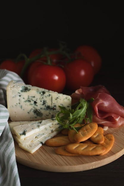 On the kitchen table is a board with fresh bruschetta with ham and cheese Along with tomatoes and g