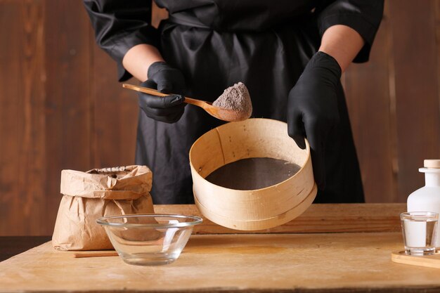 On the kitchen table is a piece of raw yeast dough male hands are holding a kitchen towel